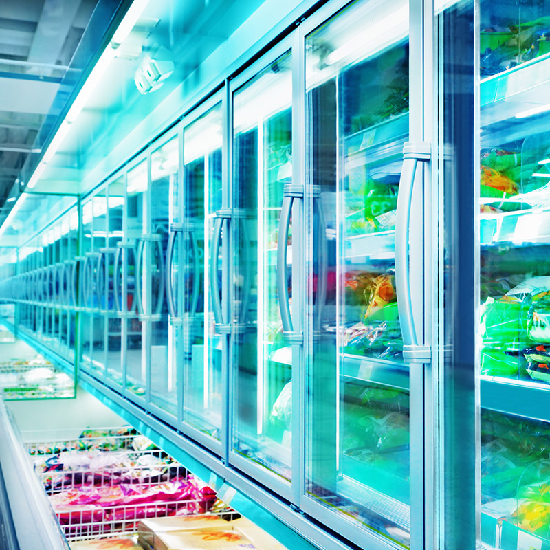 Supermarkt-Tiefkühltruhen bestückt mit Lebensmitteln verpackt in Plastik und Papier  